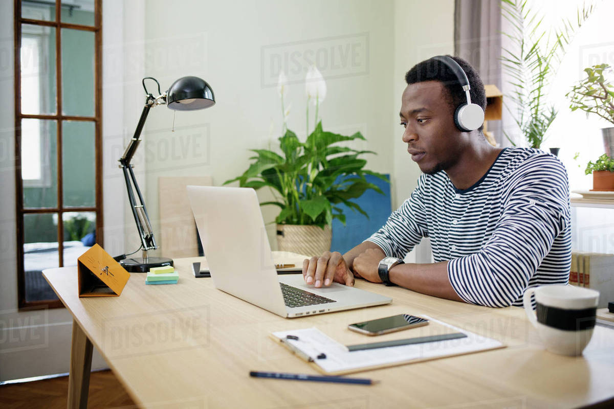 Young man listening to music while working